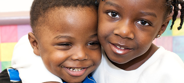 Two young kids hugging and smiling