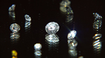 Photo of diamonds shining on a dark reflective surface